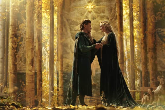 Robert Aramayo as Elrond and Morfydd Clark as Galadriel, embracing in a golden forest clearing (Credit: Ben Rothstein/Prime Video)