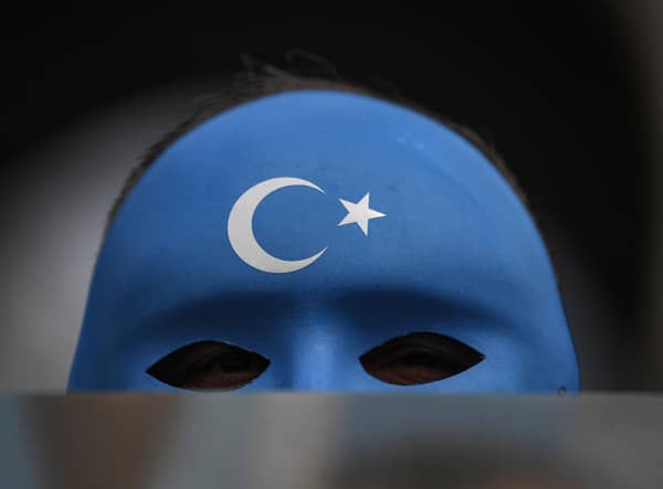 A demonstrator wearing a mask painted with the colours of the flag of East Turkestan takes part in a protest by supporters of the Uighur minority on April 1, 2021 at beyazid square in Istanbul