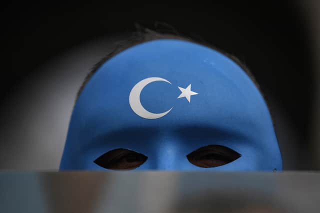 A demonstrator wearing a mask painted with the colours of the flag of East Turkestan takes part in a protest by supporters of the Uighur minority on April 1, 2021 at beyazid square in Istanbul