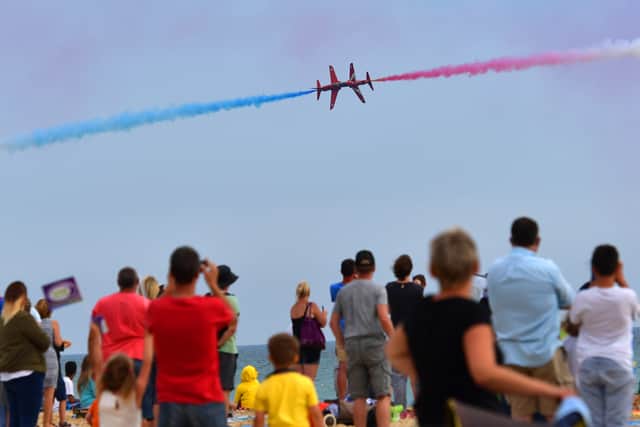 People watch as the Red Arrows aerobatics display team perform during the Bournemouth Air Festival on August 18, 2016. (Photo by Carl Court/Getty Images)