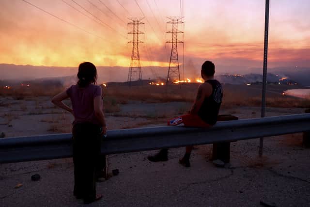 CASTAIC, CALIFORNIA - AUGUST 31: Residents who were evacuated from their home watch as the Route Fire burns on August 31, 2022 near Castaic, California. Evacuations have been ordered as the brush fire has scorched more than 4,600 acres and closed down the 5 freeway at the start of a brutal heat wave in Southern California. The National Weather Service issued an Excessive Heat Warning for most of Southern California through Labor Day. Climate models almost unanimously predict that heat waves will become more intense and frequent as the planet continues to warm. (Photo by Mario Tama/Getty Images)