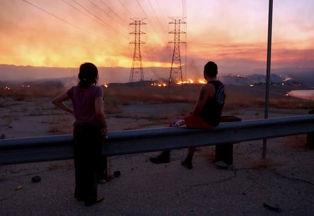 CASTAIC, CALIFORNIA - AUGUST 31: Residents who were evacuated from their home watch as the Route Fire burns on August 31, 2022 near Castaic, California. Evacuations have been ordered as the brush fire has scorched more than 4,600 acres and closed down the 5 freeway at the start of a brutal heat wave in Southern California. The National Weather Service issued an Excessive Heat Warning for most of Southern California through Labor Day. Climate models almost unanimously predict that heat waves will become more intense and frequent as the planet continues to warm. (Photo by Mario Tama/Getty Images)