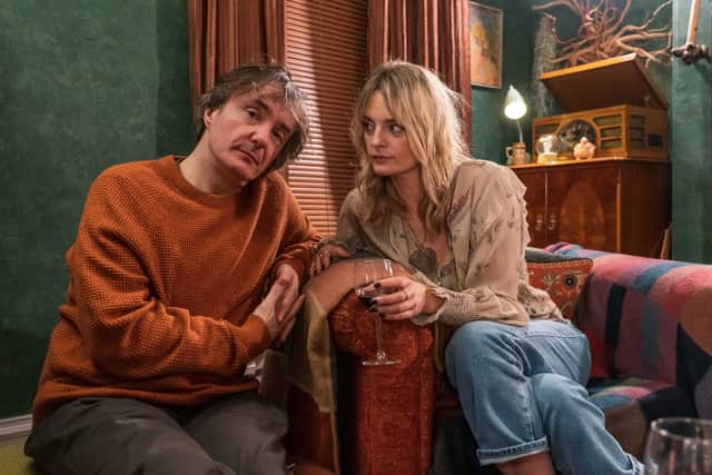 Dylan Moran as Dan and Morgana Robinson as Carla in Stuck. They’re leaning towards each other, and Carla is holding a glass of wine (Credit: BBC/Chris Barr)