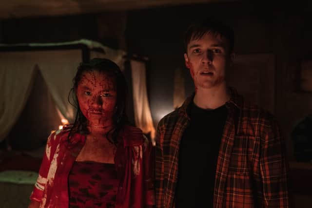 Thaddea Graham as Vivian, covered in blood, and Oscar Kennedy as Jamie, looking frightened, in a scene from Wreck (Credit: BBC/Euston Films)