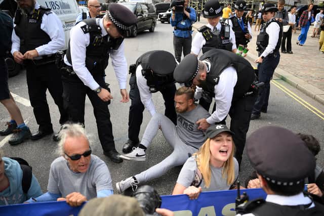 Police arrest a protester outside the venue. (Credit: Getty Images)