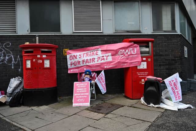 Post boxes with a banner across them are pictured on a Royal Mail postal workers picket line outside a delivery office in north London on September 8, 2022 during a strike (Photo by JUSTIN TALLIS/AFP via Getty Images)