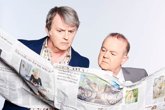 Paul Merton and Ian Hislop, reading oversized broadsheet newspapers, pulling faces of exaggerated concern (Credit: BBC/Hat Trick/Ray Burmiston)