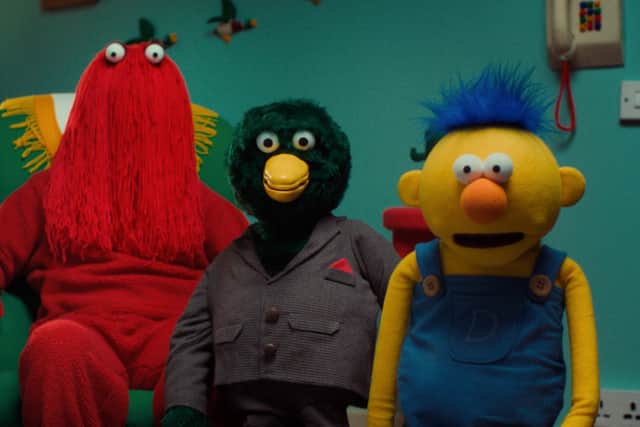 The moplike Red Guy, green Duck, and felt puppet Yellow Guy at home (Credit: Channel 4)