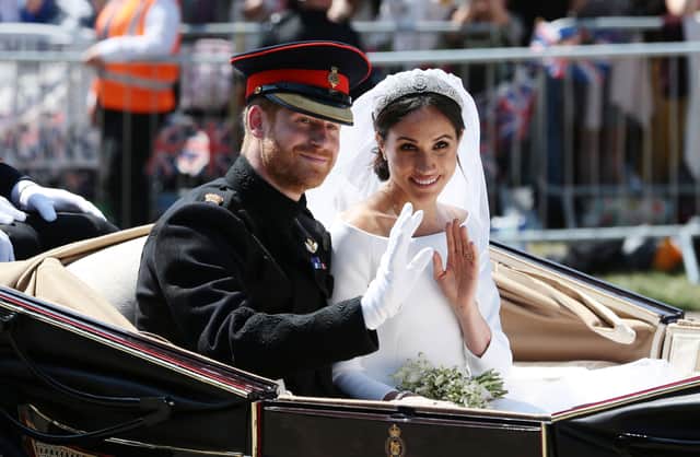 Prince Harry, Duke of Sussex and Meghan, Duchess of Sussex wave from the Ascot Landau Carriage during their carriage procession on Castle Hill outside Windsor Castle in Windsor, on May 19, 2018 after their wedding ceremony.  (Photo by Aaron Chown - WPA Pool/Getty Images)