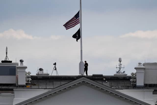 A man lowers the White House US flag to half-mast following the death of Queen Elizabeth II (Pic: AFP via Getty Images)