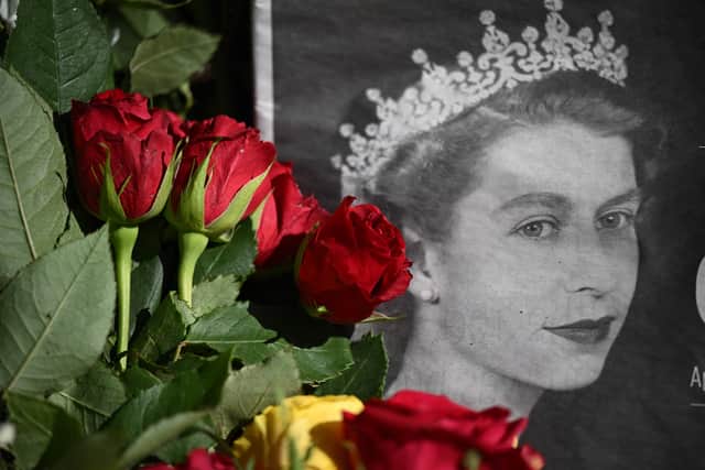 TOPSHOT - Flowers laid by well-wishers are pictured at the Palace of Holyroodhouse in Edinburgh on September 10, 2022, two days after Queen Elizabeth II died at the age of 96. - King Charles III pledged to follow his mother's example of "lifelong service" in his inaugural address to Britain and the Commonwealth on Friday, after ascending to the throne following the death of Queen Elizabeth II on September 8. (Photo by Oli SCARFF / AFP) (Photo by OLI SCARFF/AFP via Getty Images)