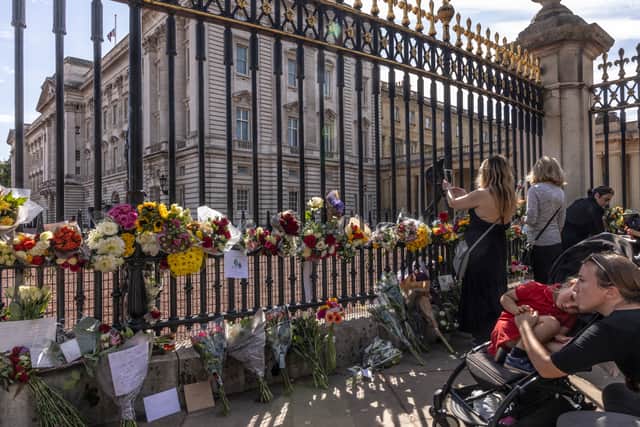Members of the public lay flowers outside Buckingham Palace following the death of Queen Elizabeth II (Pic: Getty Images)