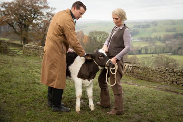 Nicolas Ralph as James Herriot, tending to an elderly woman's goat. (Credit: Playground Entertainment)