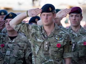 Prince Harry salutes as he joins British troops and service personal remaining in Afghanistan as they gather for a Remembrance Sunday service at Kandahar Airfield in 2014 (Photo: Matt Cardy/Getty Images)