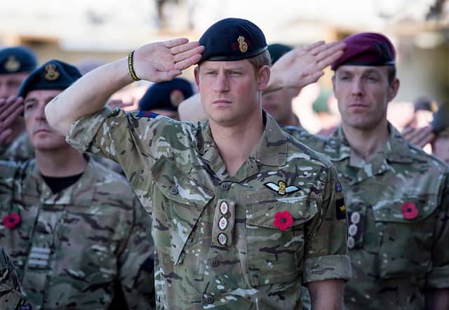 Prince Harry salutes as he joins British troops and service personal remaining in Afghanistan as they gather for a Remembrance Sunday service at Kandahar Airfield in 2014 (Photo: Matt Cardy/Getty Images)