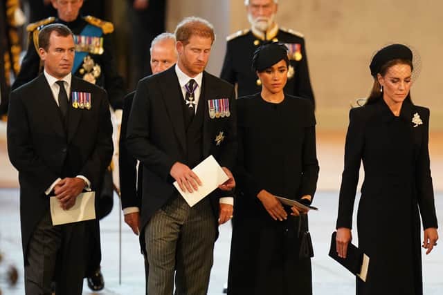 Peter Phillips, Prince Harry, Duke of Sussex, Meghan, Duchess of Sussex and Catherine, Princess of Wales stand at the coffin of Queen Elizabeth II 
