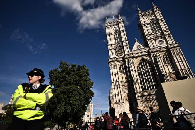 Members of the public walk past Westminster Abbey, where the funeral of Queen Elizabeth II will take place, in London on September 17, 2022. - Queen Elizabeth II will lie in state in Westminster Hall inside the Palace of Westminster, until 0530 GMT on September 19, a few hours before her funeral, with huge queues expected to file past her coffin to pay their respects. (Photo by Ben Stansall / various sources / AFP) (Photo by BEN STANSALL/AFP via Getty Images)