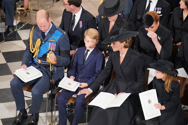 Prince George and Princess Charlotte sitting with their parents.
