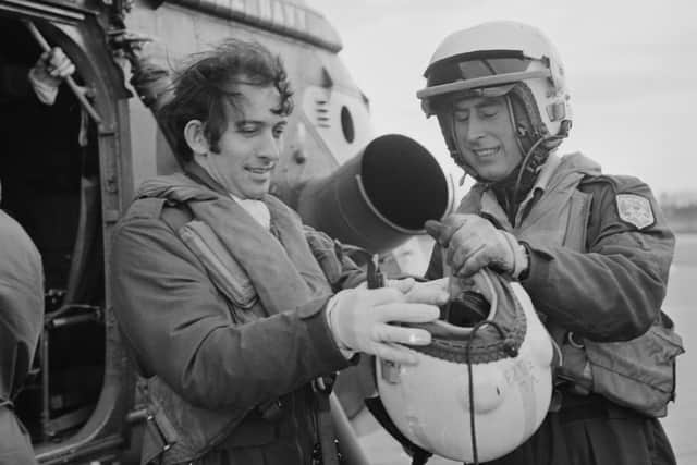 Prince Charles helping a colleague to put on his helmet, during his time with the 845 Naval Air Squadron, 8th January 1975. (Photo by Aubrey Hart/Evening Standard/Getty Images)