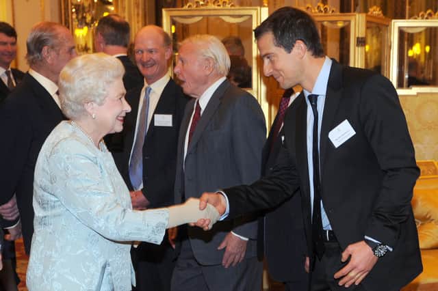 Queen Elizabeth II shakes hands with Bear Grylls at Buckingham Palace in December 2011. (Photo byAnthony Devlin - WPA Pool/Getty Images)