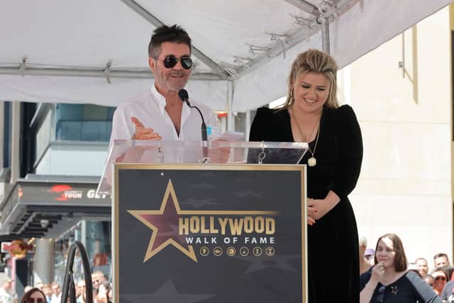 Simon Cowell and Kelly Clarkson speak onstage during The Hollywood Walk Of Fame Star Ceremony for Kelly Clarkson on September 19, 2022 in Los Angeles, California. (Photo by Kevin Winter/Getty Images)
