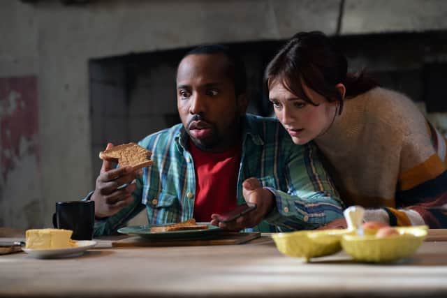 Kiell Smith-Bynoe as Mike and Charlotte Ritchie as Alison in Ghosts Series 4, eating toast and looking concerned (Credit: BBC/Monumental/Robbie Gray)