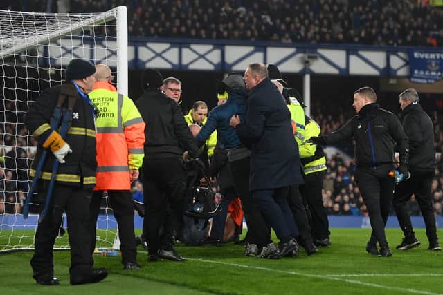 A pitch invader is arrested by police after tying himself to the net during the Premier League match between Everton and Newcastle United at Goodison Park on March 17, 2022 in Liverpool, England. (Photo: Michael Regan/Getty Images)