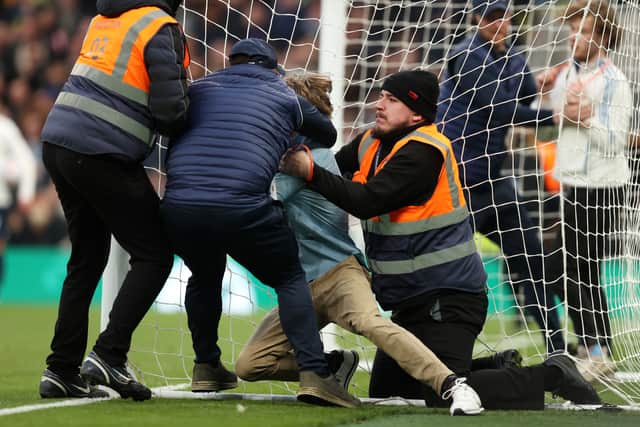 A pitch invader is apprehended by a steward during the Premier League match between Tottenham Hotspur and West Ham United at Tottenham Hotspur Stadium on March 20, 2022. (Photo: Julian Finney/Getty Images)
