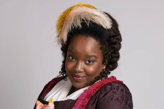 Lolly Adefope as Kitty in Ghosts, with a yellow feather in her hair (Credit: BBC/Monumental/Guido Mandozzi)