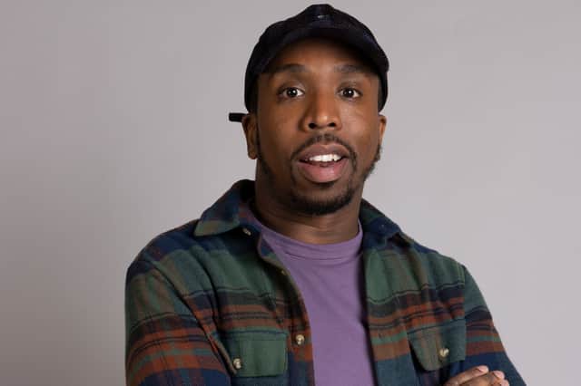 Kiell Smith-Bynoe as Mike in Ghosts, wearing a green checked shirt over a purple t-shirt, and a nice hat (Credit: BBC/Monumental/Guido Mandozzi)