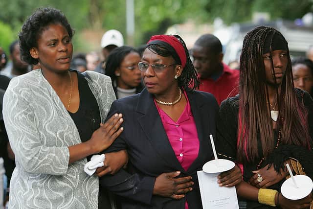 Mother of 18-year-old Anthony Walker, Gee Walker is consoled during a candlelit procession from St.Gabriel’s church in Hall Lane to McGoldrick Park, Huyton to pay their respects at the scene of the attack on August 5, 2005 in Liverpool, England.  (Photo by Matthew Lewis/Getty Images)