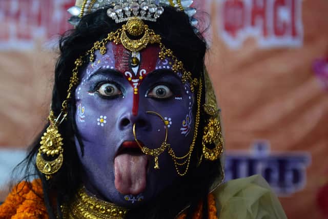 An artist dressed as the Hindu Goddess Kali performs a traditional dance during the Navaratri (nine nights) festival celebrations in Allahabad on October 20, 2020. 