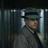 Volker Bruch as Inspector Gereon Rath in Babylon Berlin, stood in a dark alley with a fedora angled over his face (Credit: Frédéric Batier/X Filme)
