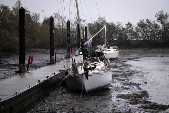 Sail boats lie on the bottom of Charlotte Harbor during a tide retreat as the eye of Hurricane Ian passes by (Photo by RICARDO ARDUENGO/AFP via Getty Images)