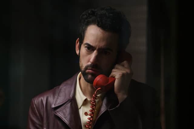 Luis Gerardo as Belascoarán in Belascoarán PI, answering a red telephone (Credit: Camila Jurado/Netflix)
