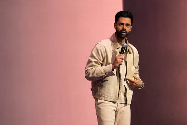 Hasan Minhaj, wearing white and performing standup at the Brooklyn Academy of Music (Credit: Clifton Prescod/Netflix)
