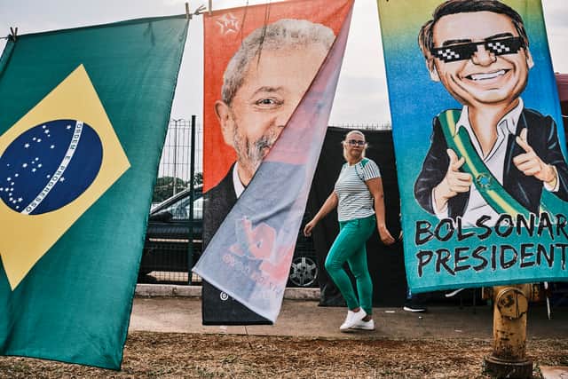 A woman walks by flags of presidential candidates Luiz Inacio Lula da Silva and Jair Bolsonaro in Brasilia (Getty Images)