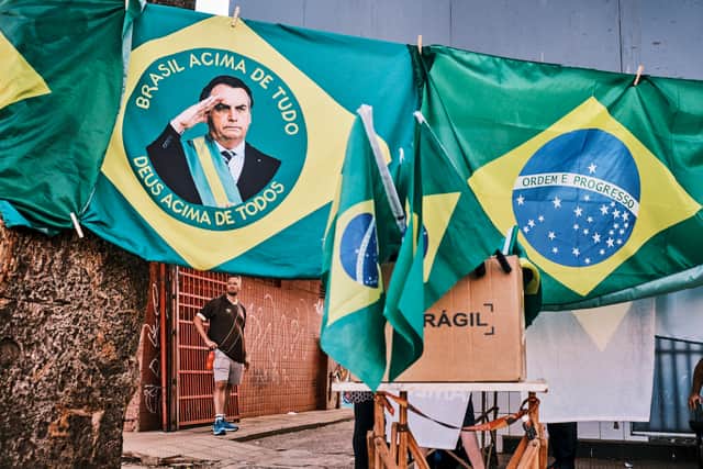 A man stands by a street stall selling flags of presidential candidate Jair Bolsonaro (Getty Images)