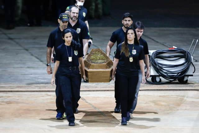 One of the coffins containing human remains found during the search for missing British journalist Dom Phillips and indigenous expert Bruno Pereira in the Amazon forest, is taken to the Federal Police hangar after being unloaded from a plane in Brasilia (AFP via Getty Images)