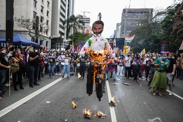 Demonstrators burn a doll depicting Brazilian President Jair Bolsonaro during a protest (Pic: Getty Images)