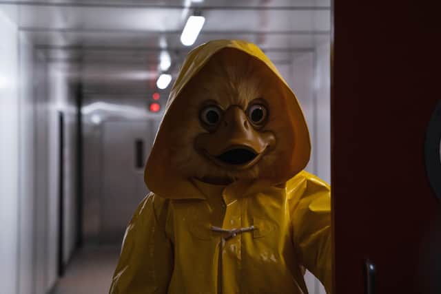 Quacky, a duck mascot in a yellow raincoat, looking vengeful (Credit: BBC/Euston Films/Peter Marley)
