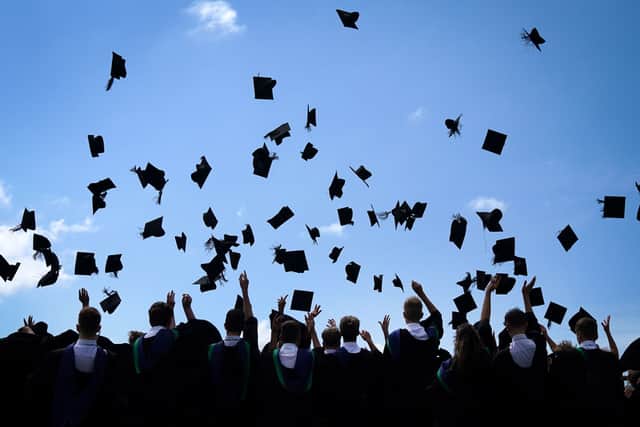 Students celebrate their graduation by throwing their mortaboard hats in the air. (Photo by Christopher Furlong/Getty Images)