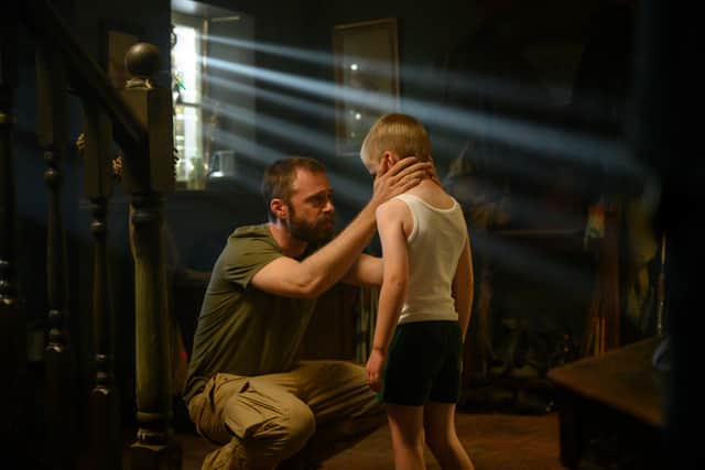 Rory Keenan as Steve with Samuel McKenna as young Danny, kneeling to look him in the eye (Credit: Parisa Taghizadeh/Channel 4/BBC)