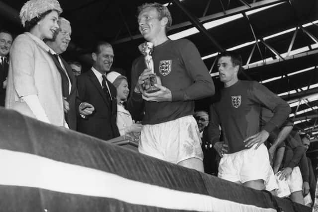 Queen Elizabeth II smiles after presenting England captain Bobby Moore with the Jules Rimet trophy in 1966 (Getty Images)