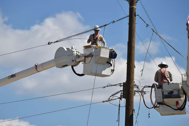 Workers repair power lines in Panama City, Florida, on October 14, 2018. (Photo by HECTOR RETAMAL/AFP via Getty Images)