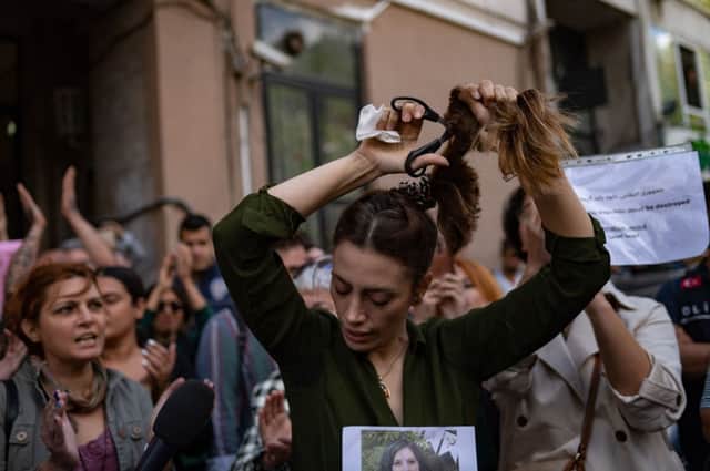 Nasibe Samsaei, an Iranian woman living in Turkey, cuts her ponytail off during a protest outside the Iranian consulate in Istanbul. Credit: Getty Images
