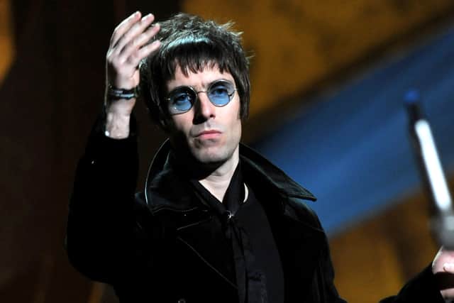 Liam Gallagher throws his microphone into the audience after accepting Oasis' award for 'Best Album of 30 Years' on stage at The Brit Awards 2010