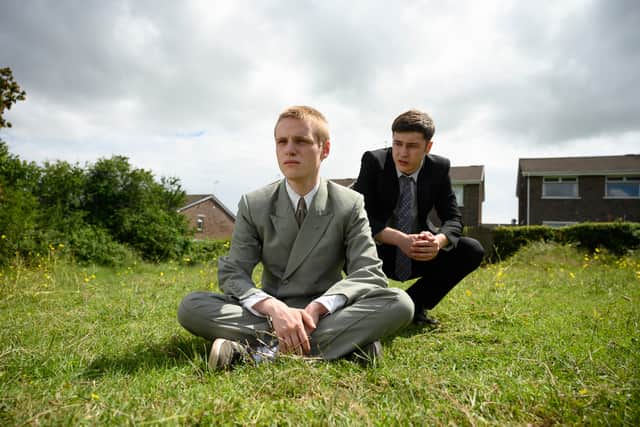 Lewis Gribben as Danny and Samuel Bottomley as Aaron in Somewhere Boy, wearing suits and sat in the garden (Credit: Channel 4) 