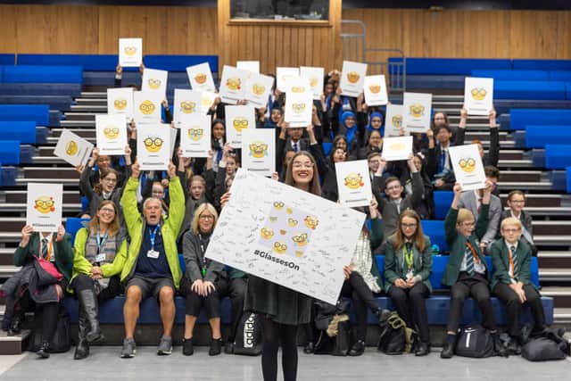 Lowri Moore, who has launched a campaign calling for tech companies to make more emojis with glasses on, with students and staff at Padget High School who support her.