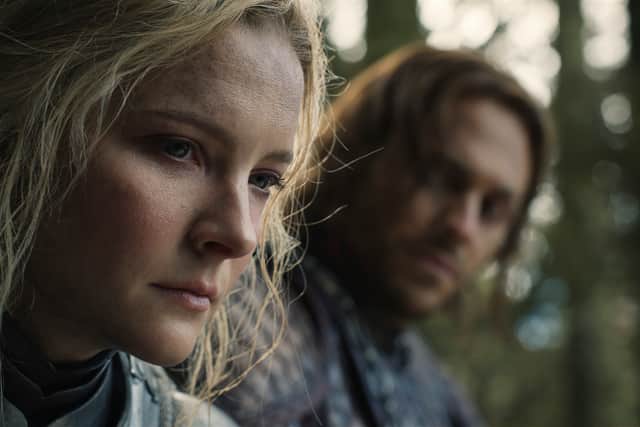 Morfydd Clark as Galadriel, deep in thought and being watched by Charlie Vickers’ Halbrand (Credit: Amazon Studios)